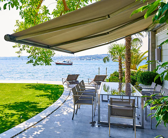 Awning shading an outdoor dining area with sea views